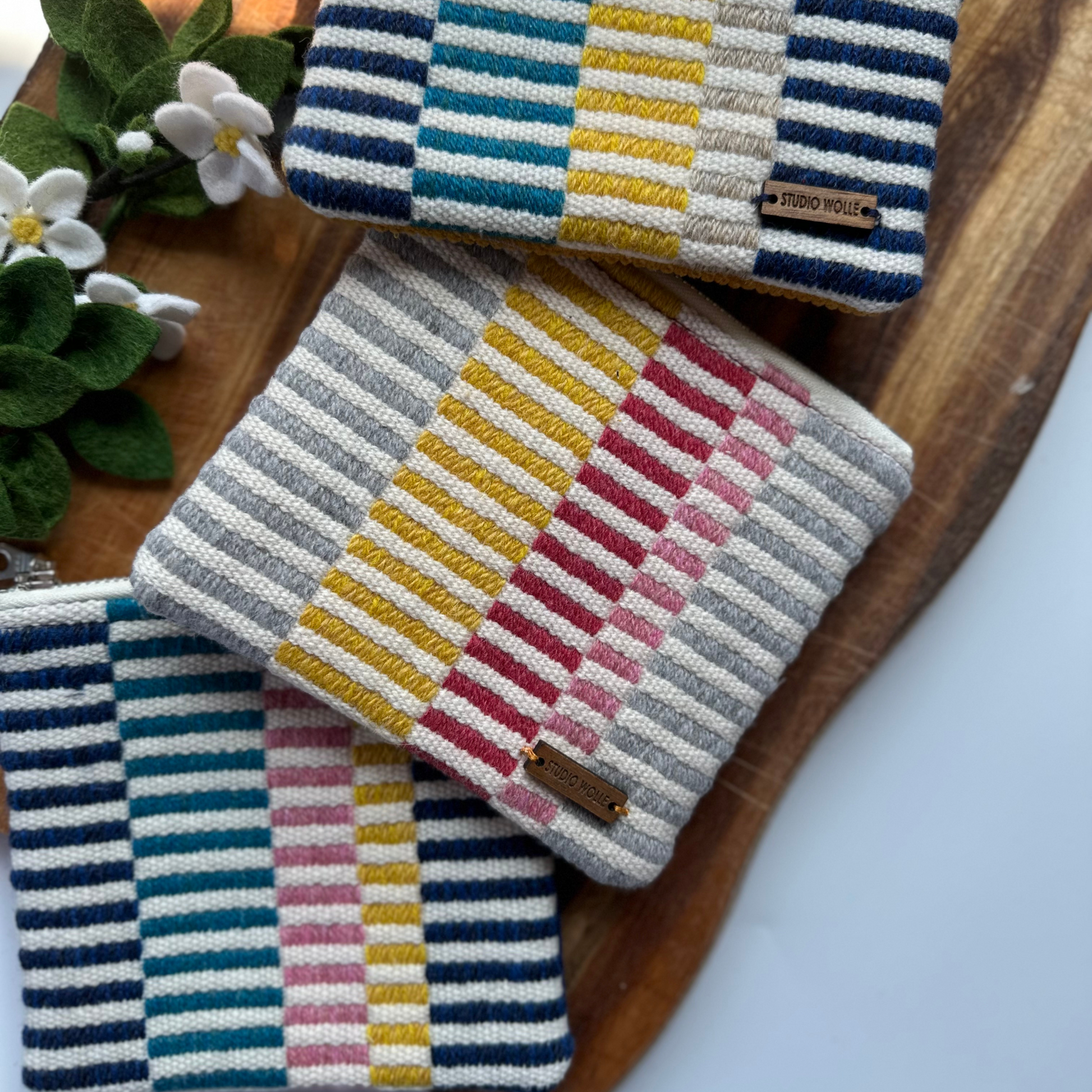 a group of striped handwoven zipper purses 